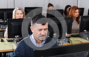 Succesful businessman foreground in busy open plan office