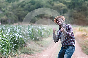 Success african farmer man stand at the green farm with raindrop