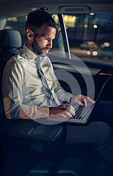 Success businessman working late in car on laptop