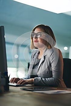 The success can endure long hours when needed. a young businesswoman working late on a computer in an office.