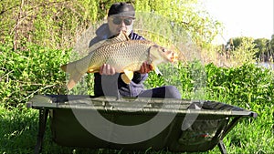 Success carp fishing. Man holding big carp in his hands