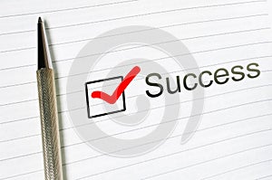 Success concept. Checkbox and pen. Success word written on lined paper