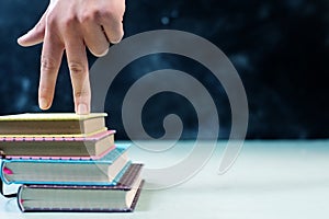 Success concept with fingers climbing stairs made of books stack