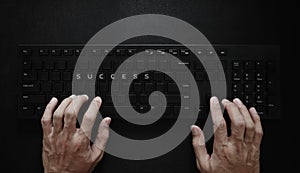 Success concept. Hand typing on computer keyboard and SUCCESS on buttons