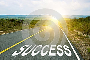 Success, concept photo of asphalt road. Motivational inscription on the road going forward. The beginning of a new path. A