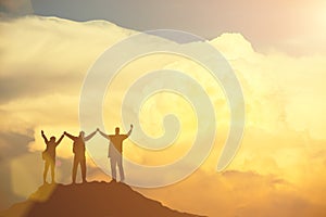 Success concept. Silhouetted of group of people raised hand up in the sky with happy.