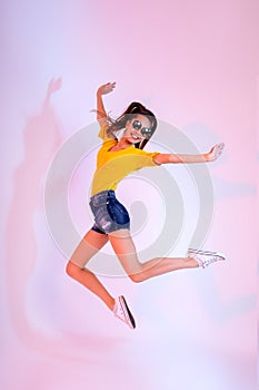 Success, dream, femenine girlish life concept. Excited brunette lady model is jumping up, wearing casual clothes, white