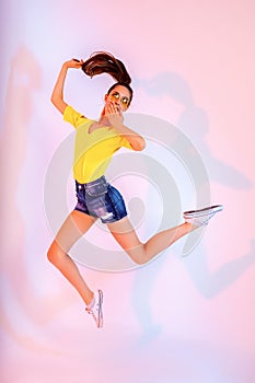 Success, dream, femenine girlish life concept. Excited brunette lady model is jumping up, wearing casual clothes, white