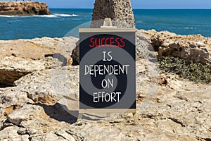 Success and effort symbol. Concept words Success is dependent on effort on beautiful black chalkboard. Beautiful stone sea