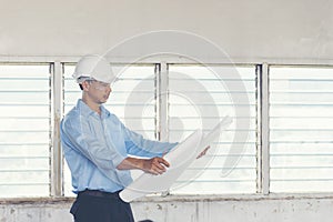 Success Engineer wear white helmet for safety and checking building plans blue print. construction Concept