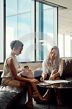 Success is guaranteed every time we work together. Full length shot of two young businesswomen going over some paperwork