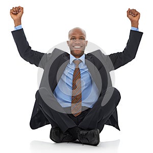 Success. A happy young african-american businessman sitting with his arms raised in an expresion of triumph.