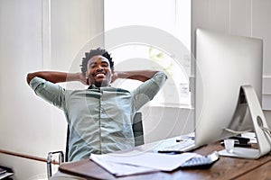 Success has got him smiling. Portrait of a young designer taking a break at his office desk.