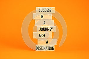Success is a journey symbol. Concept words Success is a journey not a destination on wooden blocks on a beautiful orange table