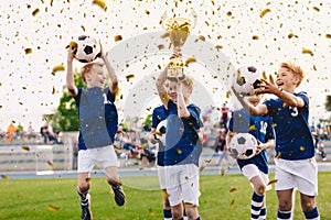 Success of kids football team in tournament final game. Happy boys in school sports team winning soccer championship