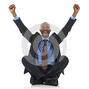 Success at last. A happy young african-american businessman sitting with his arms raised in an expresion of triumph.