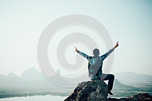 Success man hiker outstretched arms on top of the mountain .Concept of adventure travel
