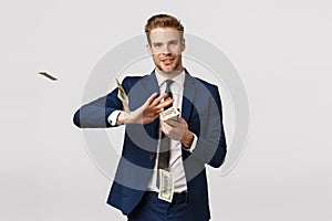 Success, money and finance concept. Handsome confident, blond bearded businessman in suit, holding cash and throwing