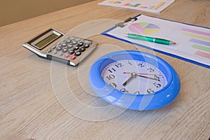 Success, motivation, financial flows. big Clock, calculator, pen, business graphics on table