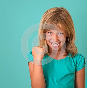 Success. Portrait winning successful little girl happy ecstatic celebrating being winner isolated turquoise background.