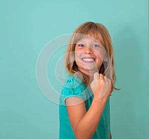 Success. Portrait winning successful little girl happy ecstatic celebrating being winner isolated turquoise background. Positive