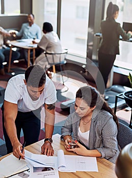 Success is projected in all their paperwork. two businesspeople going through paperwork together in an office.