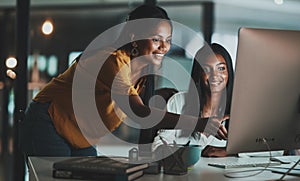 Success is something to pursue through hard work. two young businesswomen working together on a computer in an office at