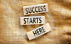 Success starts here symbol. Concept word Success starts here on beautiful wooden block. Beautiful canvas table canvas background.