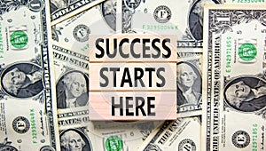 Success starts here symbol. Concept word Success starts here on beautiful wooden block. Dollar bills. Beautiful dollar bills