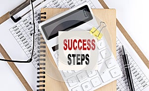 SUCCESS STEPS word on sticky with clipboard and notebook, business concept