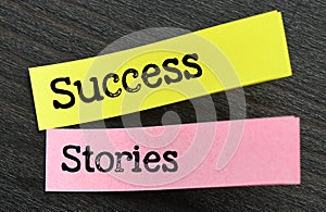 SUCCESS STORIES words on small sheets of paper and a black background