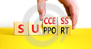 Success and support symbol. Concept word Success and Support on wooden cubes. Beautiful yellow table white background. Businessman