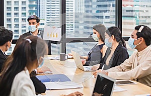 Success and Teamwork concepts, Group of young business people have a meeting in the office while wear mask as protection from