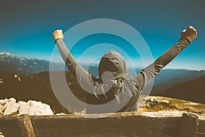 Success, triumph and victory. Victorious female person on mountain photo