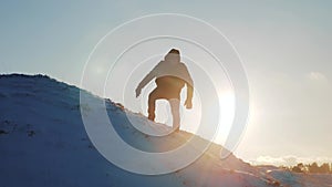 Success victory win business travel concept. man rock climber descends silhouette from the top of a snowy mountain