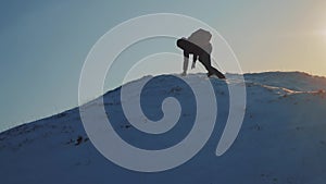 Success victory win business travel concept. man rock climber descends silhouette from the top of a snowy mountain