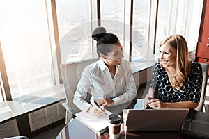 Success will inevitably be ours. two businesswomen working together on a laptop in an office.