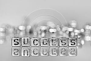 Success word written on grunge silver cube with black and white