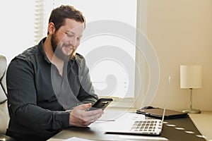 Successfel enterpreneur working with laptop and smartphone at ofice.