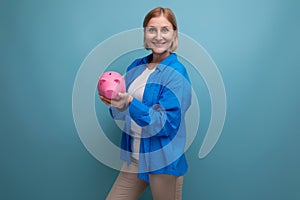 successful adult business woman with accumulated money capital on blue background with copy space