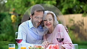 Successful adult son thanking mother for upbringing, emotional embrace love photo