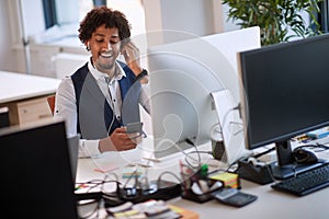 Successful african american businessman holding mobile phone call. Young business people in office