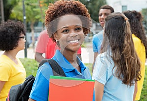 Successful african american female student with large group of i