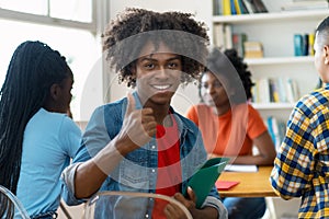 Successful african american male college student at desk at classroom