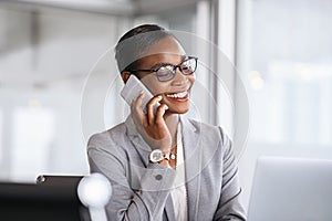 Successful african business woman talking on phone in office