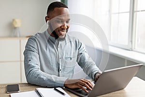 Successful African Businessman Working On Laptop Sitting In Modern Office