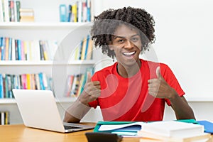 Successful afro american male student learning at desk
