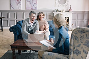Successful agent giving consultation to family couple about buying house.