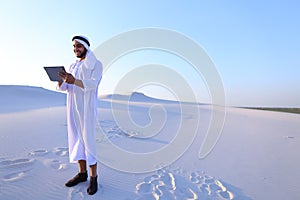 Successful Arabian businessman holds in hands and uses tablet, s