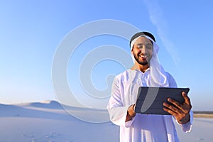 Successful Arabian businessman holds in hands and uses tablet, s